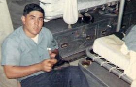 photograph of Ernie shining his shoes near his bunk 